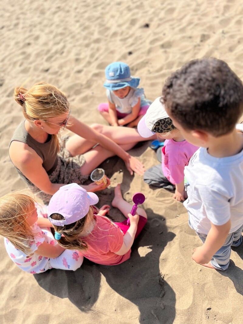 Krippen-Kinder spielen im Sand