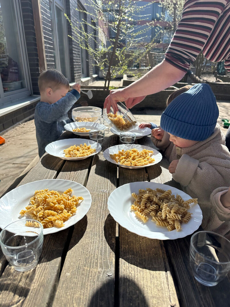 Kinder essen draussen Nudeln