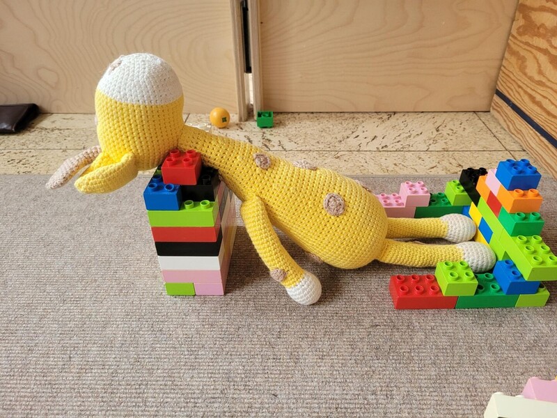 Ein Kuscheltier entspannt auf einer Liege aus Lego